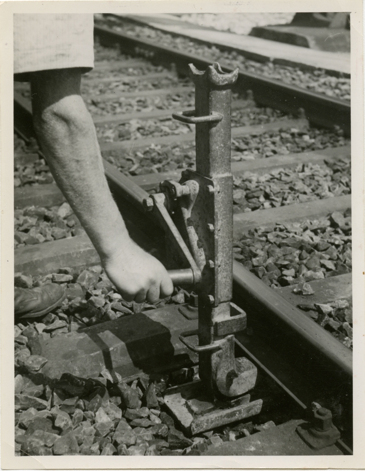 Alte schwarz-weiss Fotografie, auf der eine Zahnstangenwinde an einem Gleis abgebildet ist.